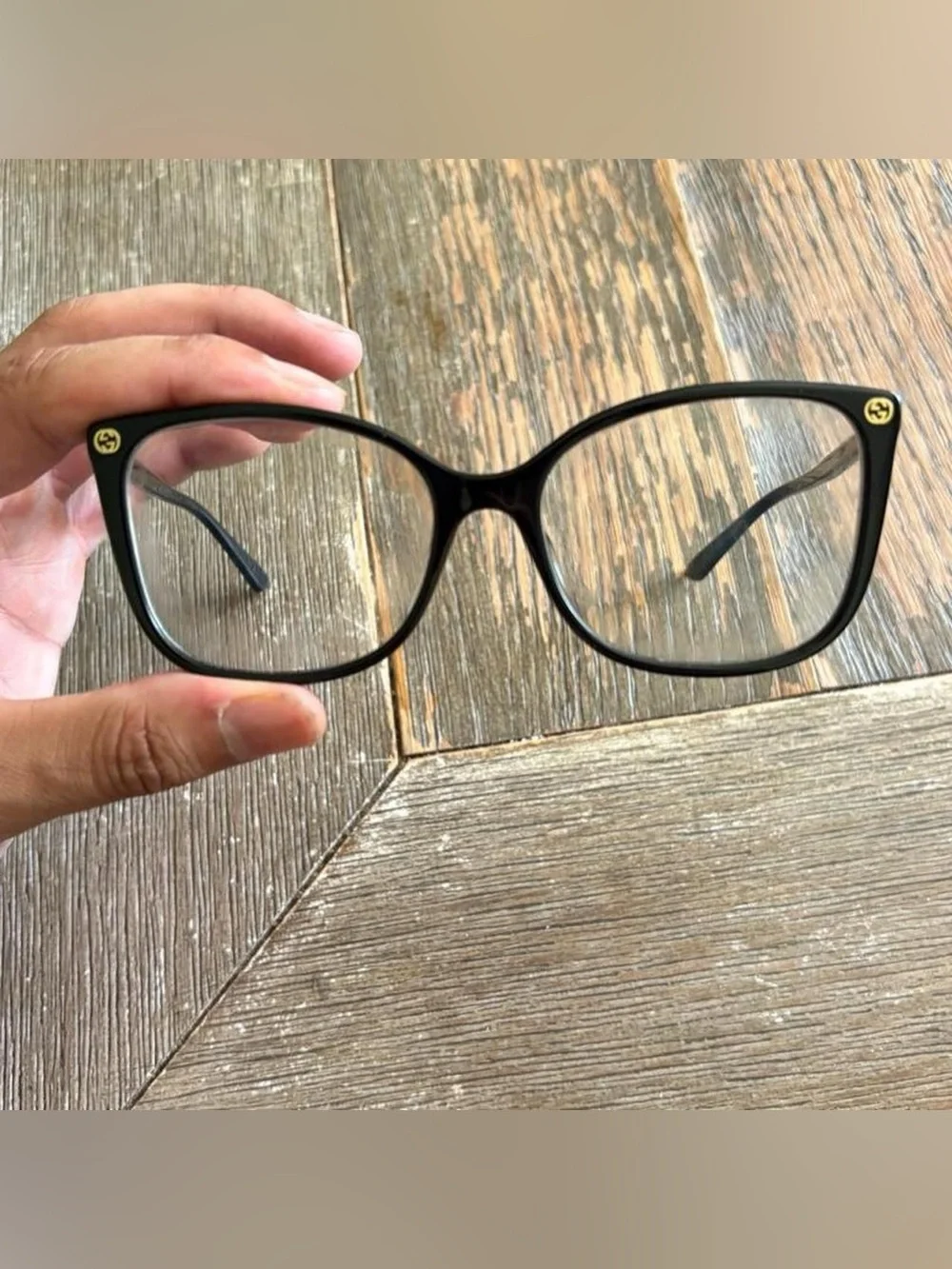 Gucci GG0026O eyeglasses in black with gold logo accents on the temples
